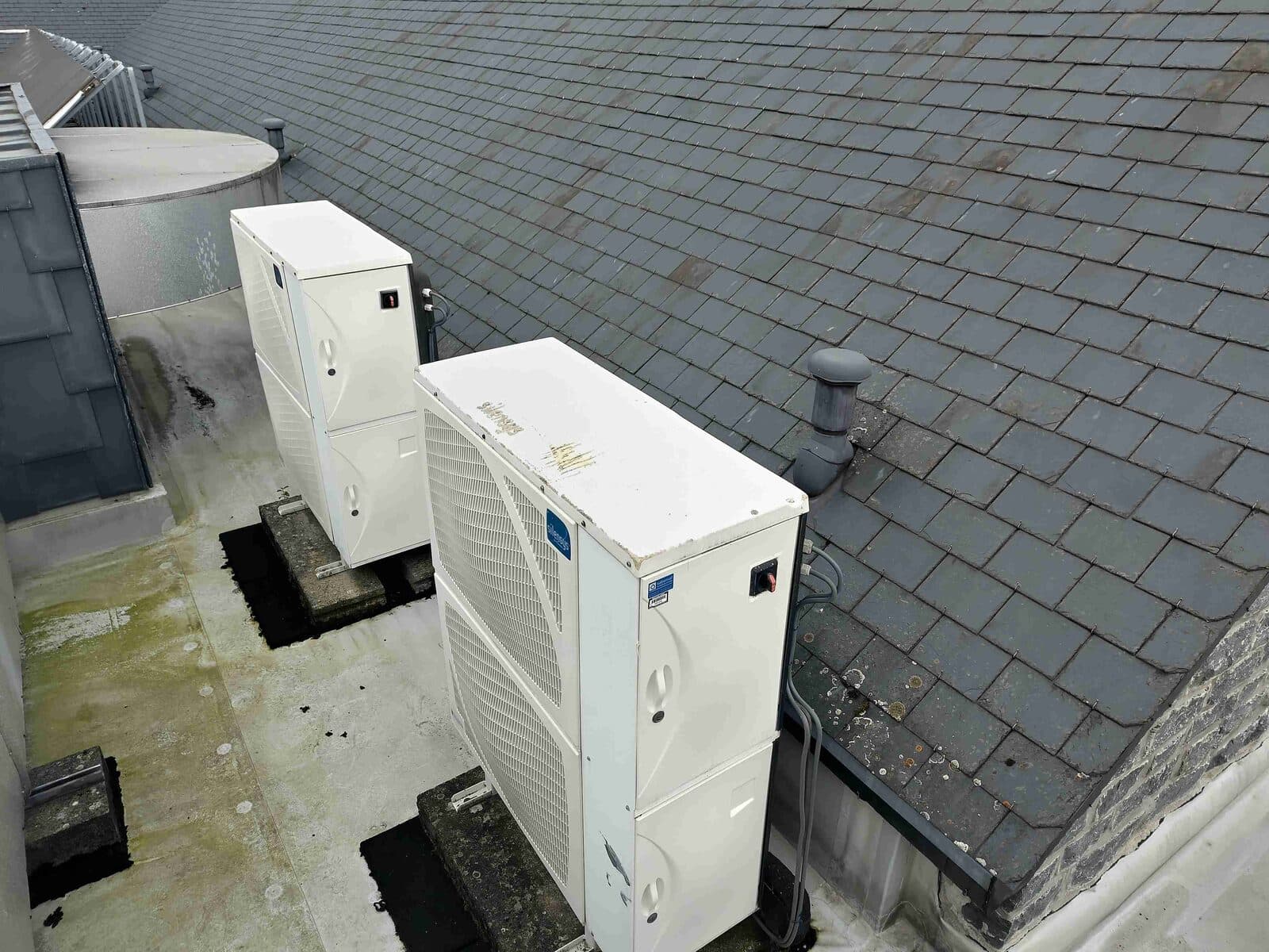 Unités extérieures d'une pompe à chaleur posées sur une toiture plate